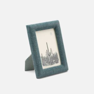 A teal fabric photo frame displays a black-and-white image of cacti.