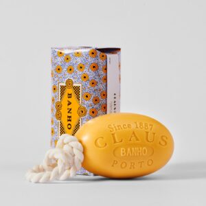 Yellow soap with a rope, next to a patterned box labeled "BANHO.