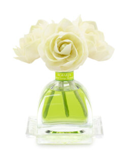 Clear glass bottle with green liquid, topped with white rose-shaped flowers.