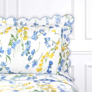 Floral-patterned bedding with blue and yellow flowers, featuring a scalloped edge.