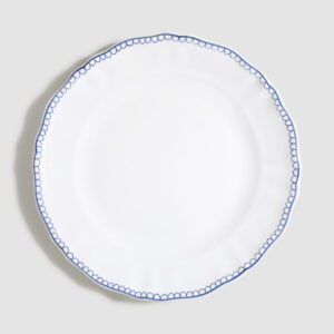 White plate with a scalloped edge and blue decorative pattern around the rim.