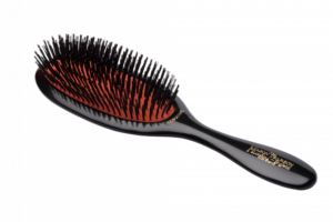A Mason Pearson hairbrush with a black handle and mixed bristles, designed for gentle styling.