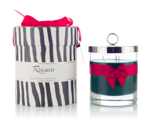 A decorative scented candle in a glass jar, accompanied by a striped gift box with a red ribbon.