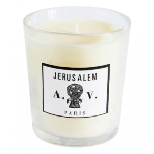 White candle in a clear glass holder with a label reading "Jerusalem A.V. Paris.