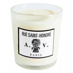 White candle in a glass holder with a label reading "Rue Saint-Honoré A.V. Paris.