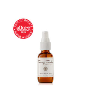 Brown glass bottle of Tammy Fender Quintessential Serum with a spray top and an award badge.