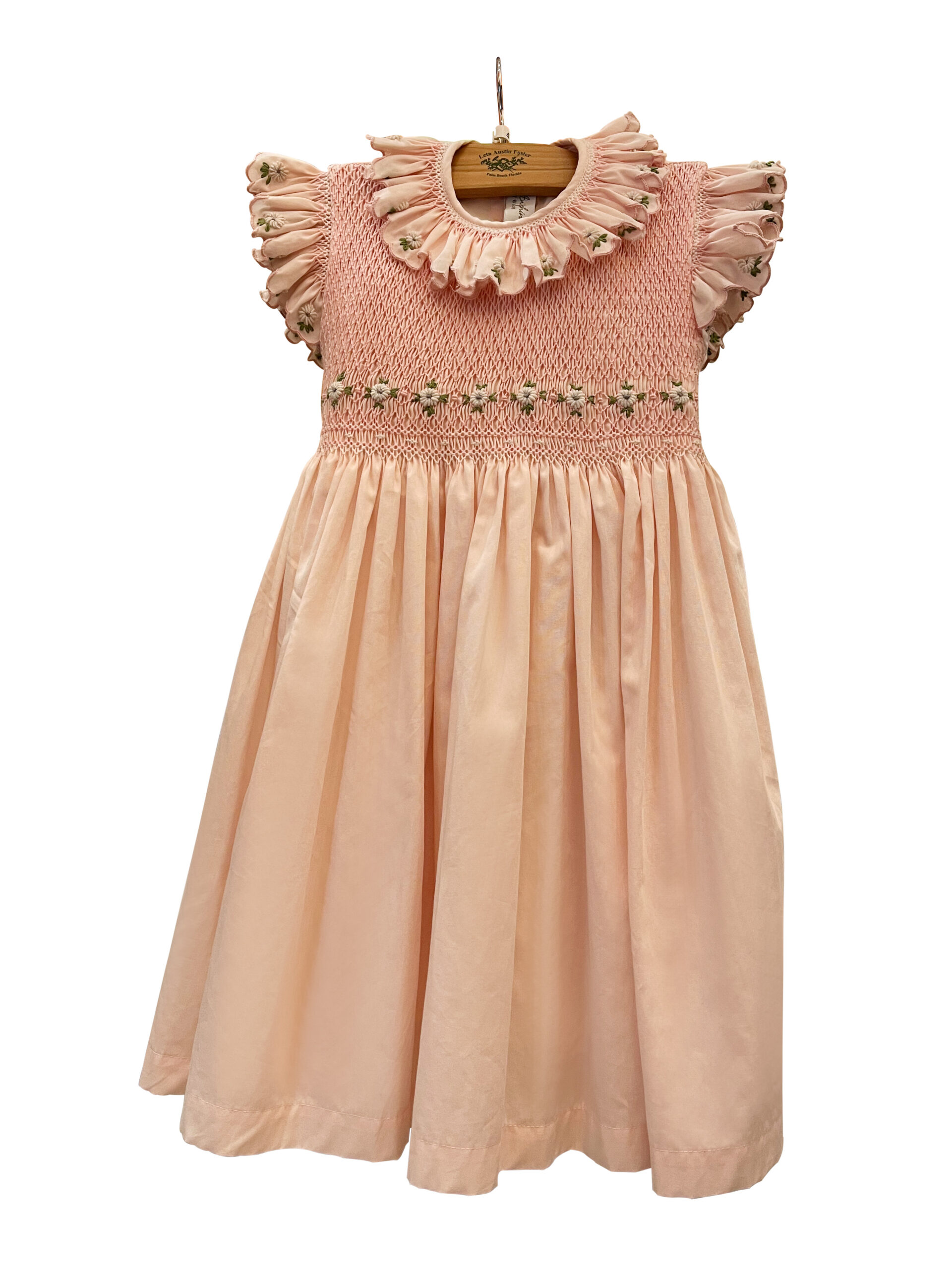 anichini-pink-cotton-dress-smocked-with-white-daisies Pink cotton dress with smocked bodice and white daisy embellishments, featuring ruffled sleeves.
