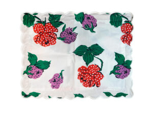 A square fabric featuring red and purple flowers with green leaves on a white background. Scalloped edges.