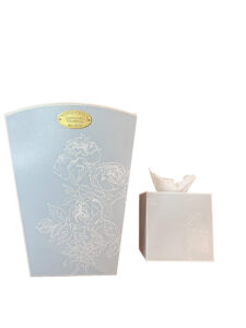 Curved-edge wastebasket and tissue box in white floral design on a French blue background.