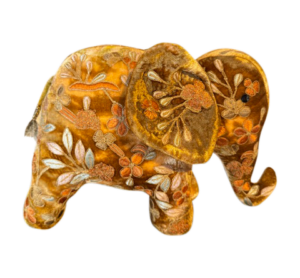 A yellow silk velvet elephant adorned with floral embroidery.