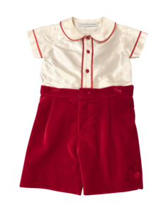 Velvet red shorts paired with a cream silk top featuring red trim and buttons.