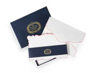 A navy box contains scalloped-edge stationery and envelopes, featuring "The Grosvenor Stationery Company" logo.