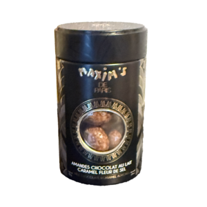 Black cylindrical container of Maxim's De Paris, showcasing milk chocolate and salted caramel covered almonds.