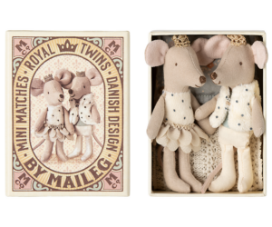Two plush mice in royal outfits stand together inside a decorative box.